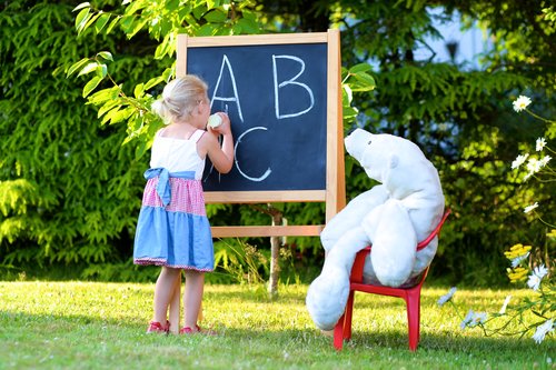 Девочка учит алфавиту игрушку
